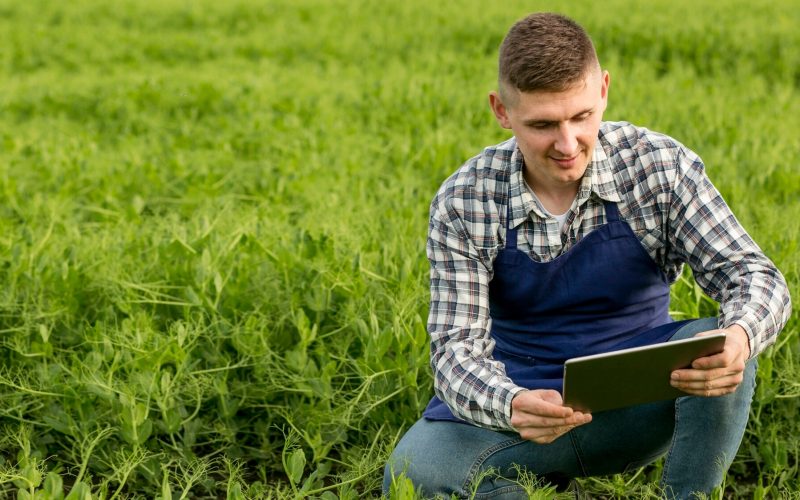 hombre-alto-angulo-granja-tableta_23-2148579696